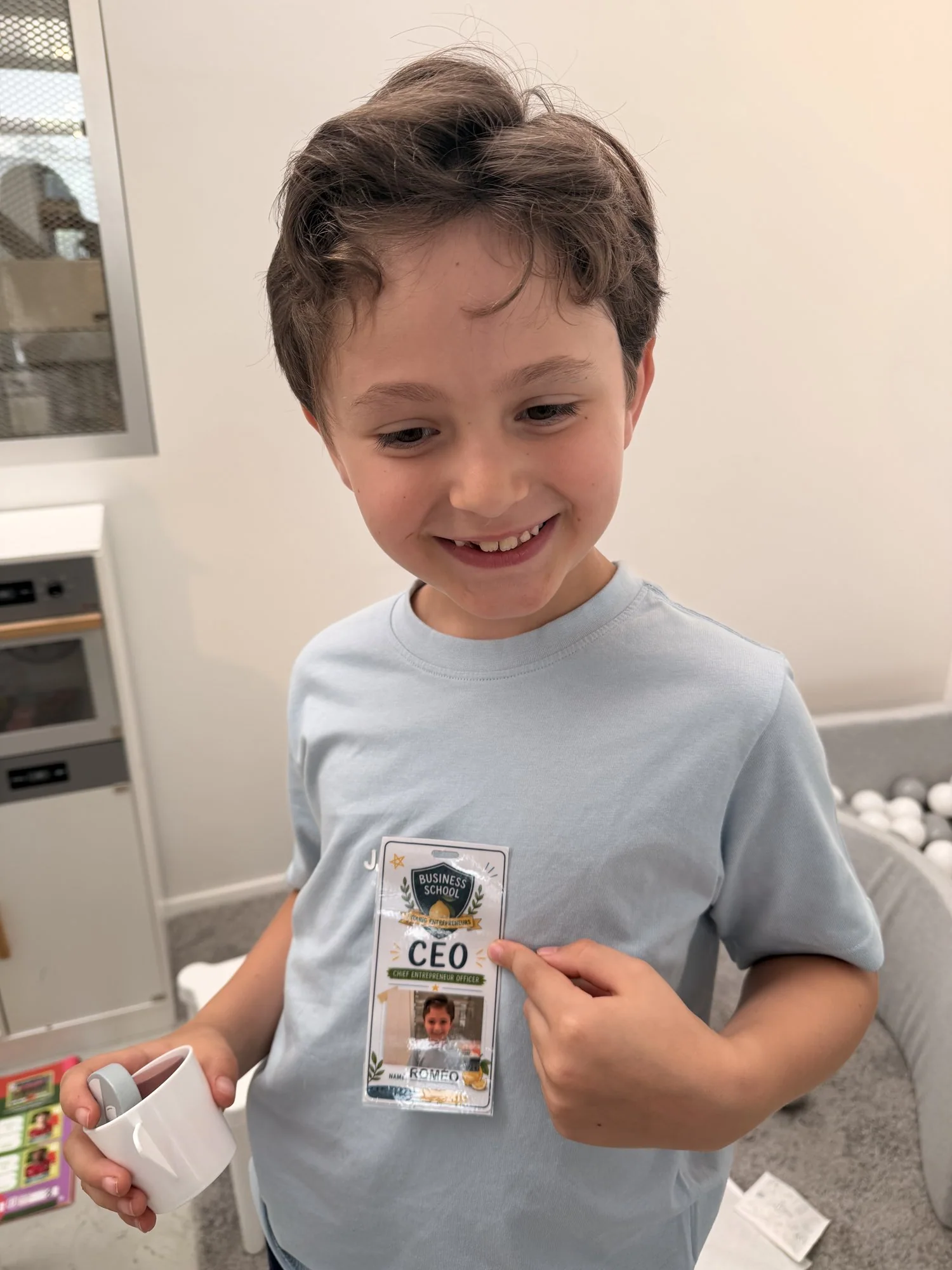 Roméo pointing at his Business School for Young Entrepreneurs CEO badge
