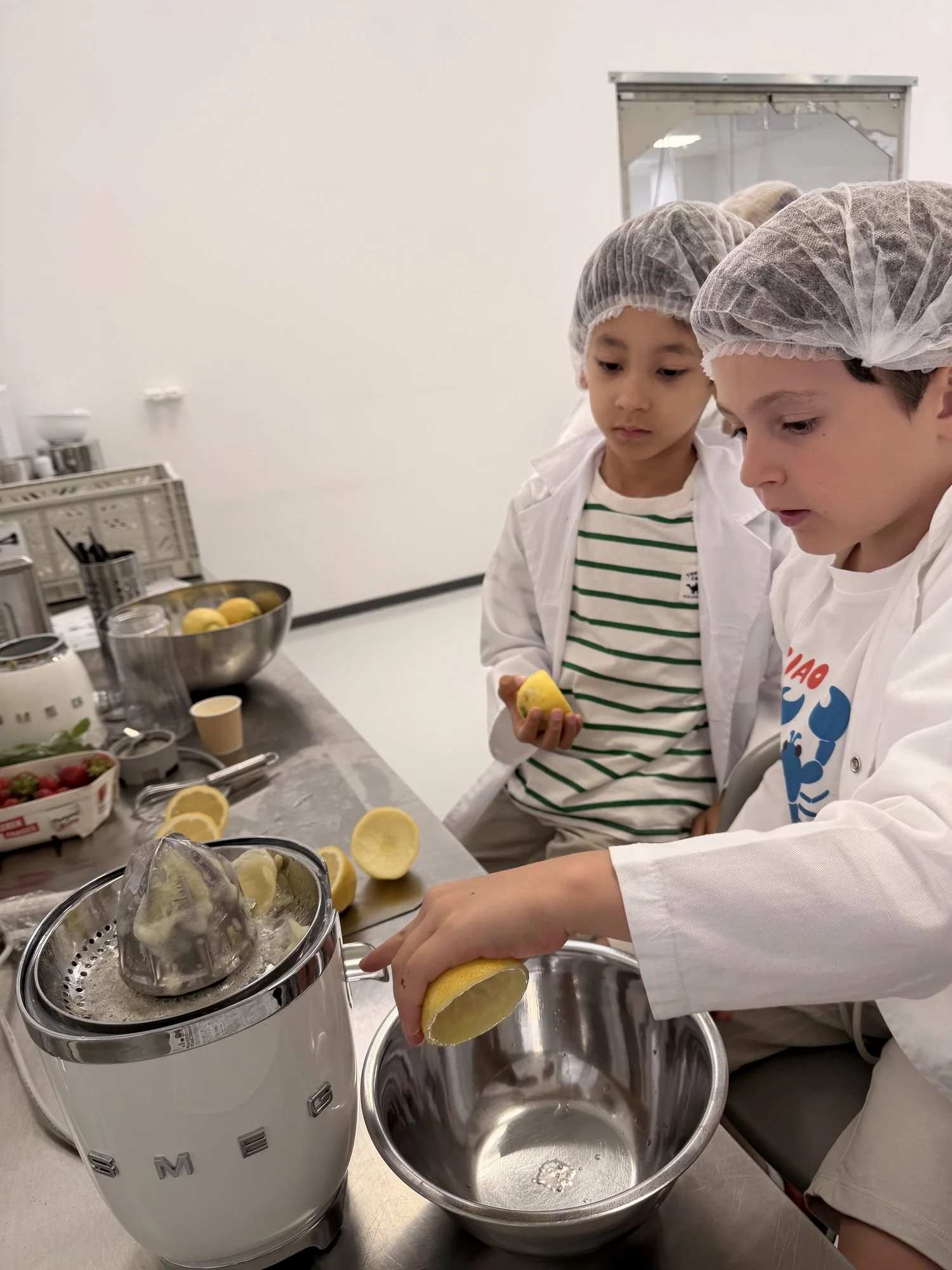 Noah and Roméo squeezing fresh lemons in the kitchen