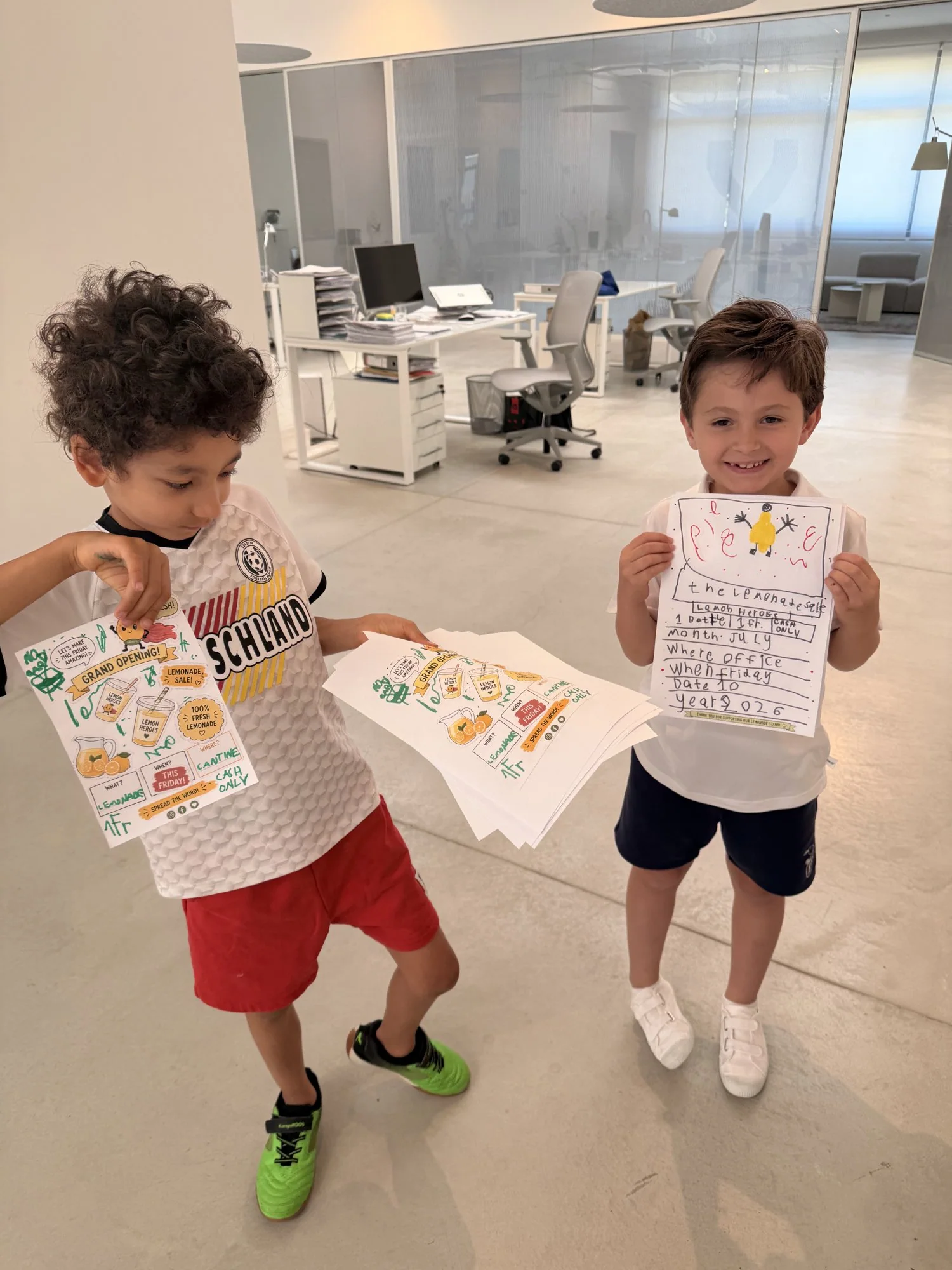 Noah and Roméo showing the Lemon Heroes t-shirts they designed